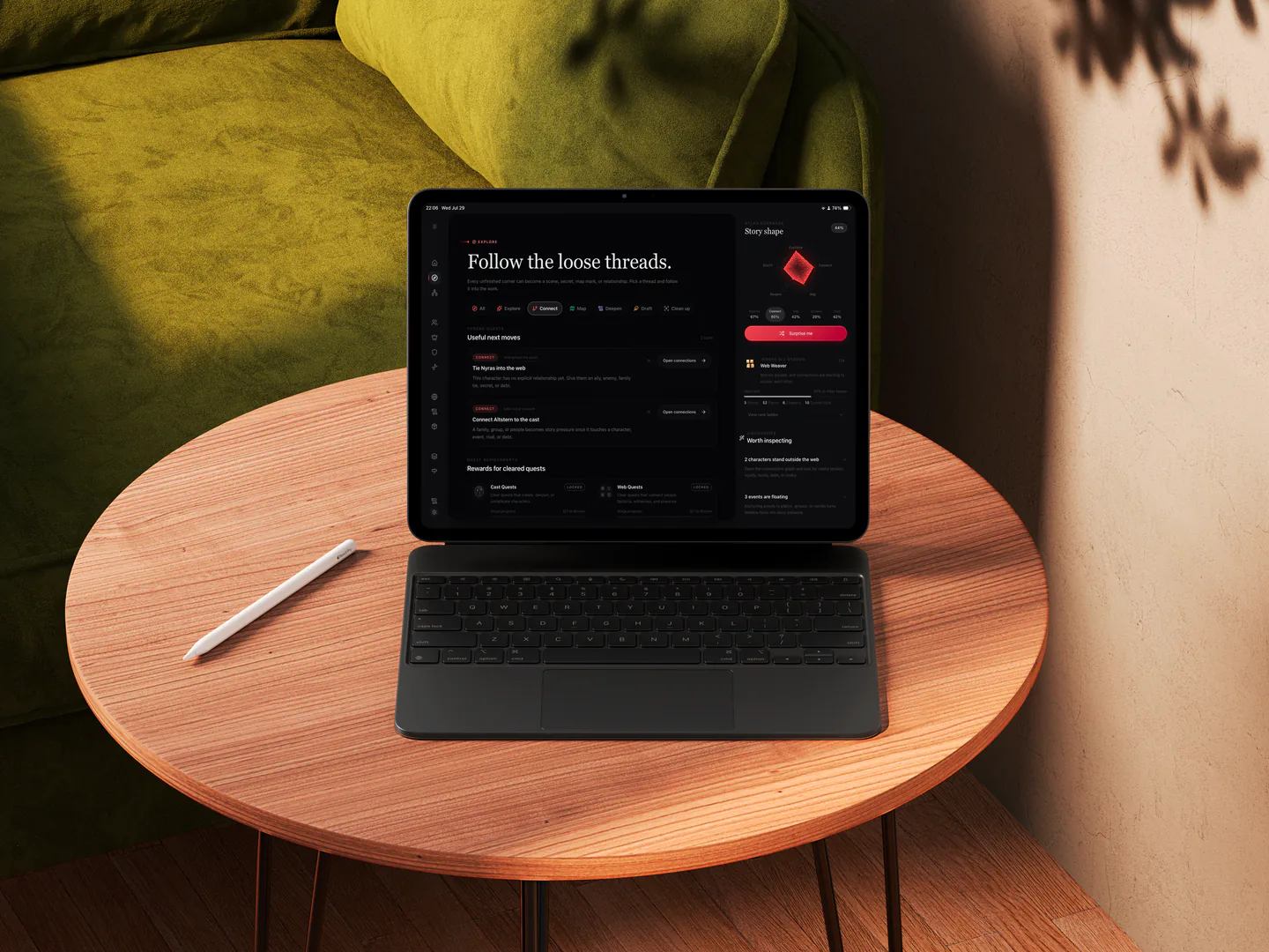 RedThread running on an iPad with Magic Keyboard on a round writing table beside a green sofa